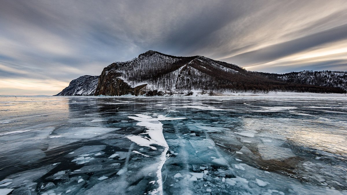 Frozen Lake Baikal in winter, featuring icy shores and rocks near Olkhon Island.
