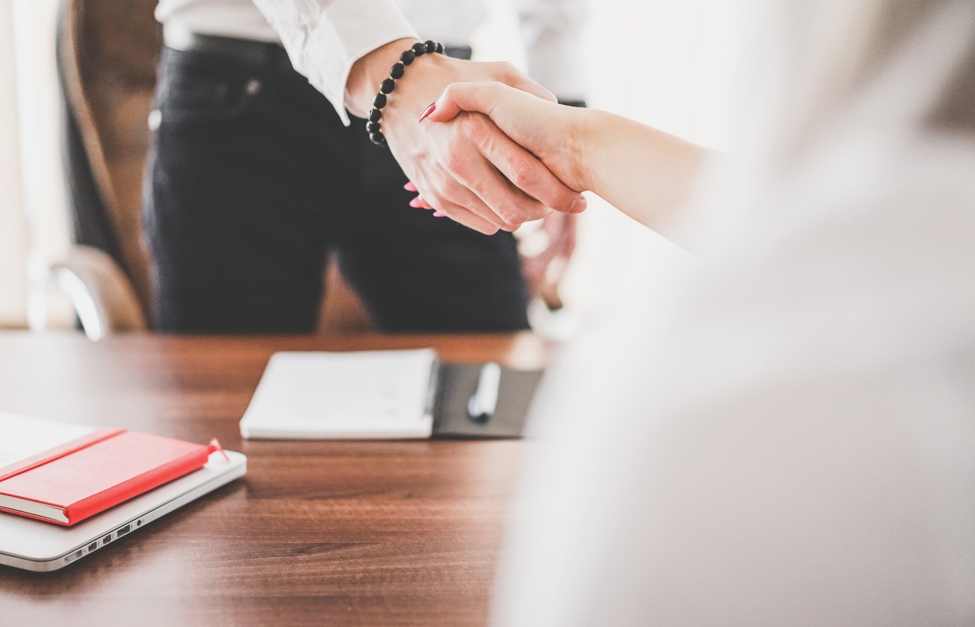 Two professionals shaking hands in an office
