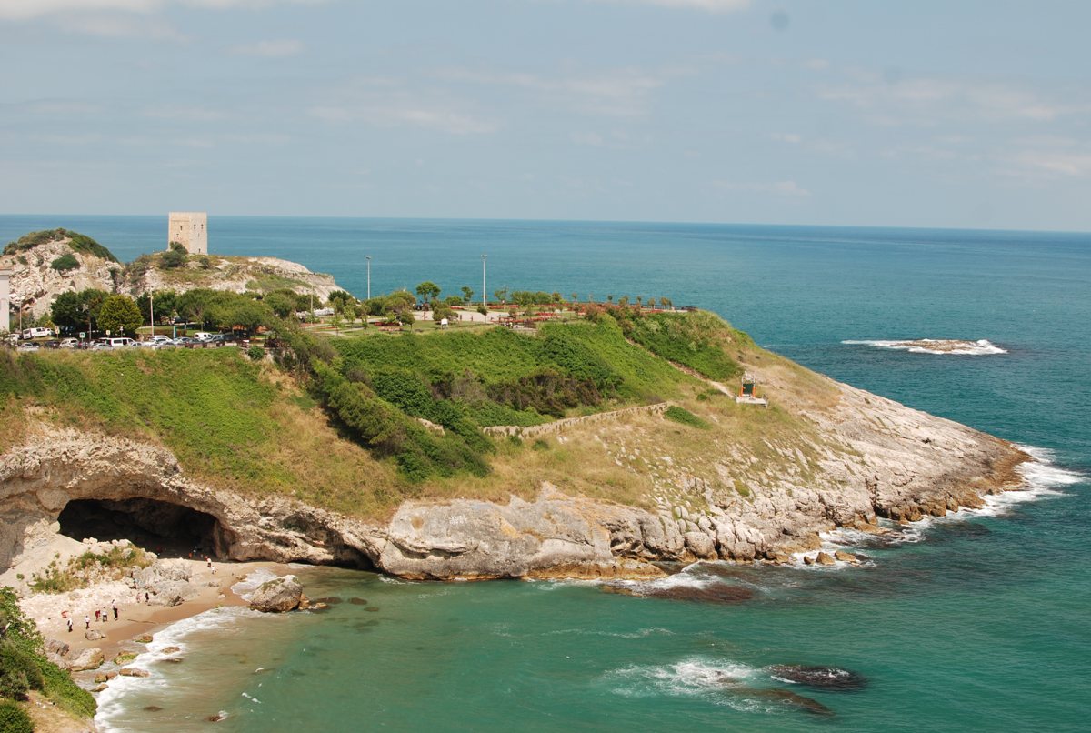 A view from the Şile Lighthouse looking toward the rocky coastline, the castle tower, and the turquoise Black Sea